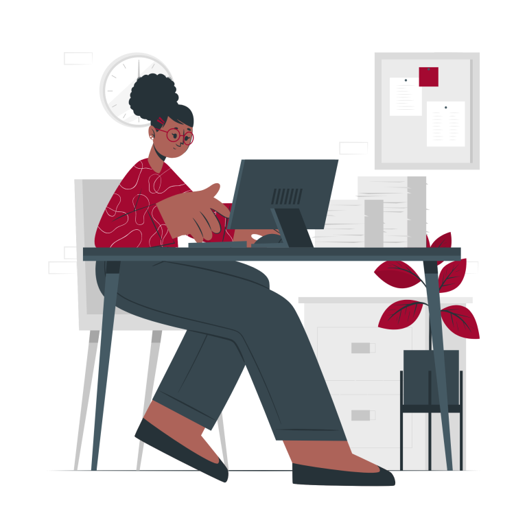 Eine Person mit Brille sitzt an einem Schreibtisch und arbeitet am Computer in einem Büro.